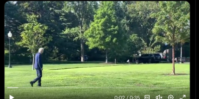 Biden walking past bushes